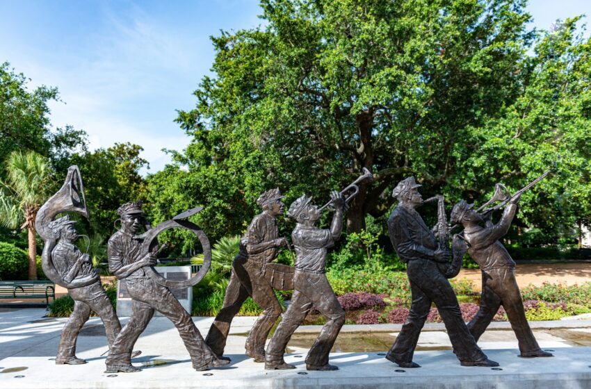 man and woman statue near green trees during daytime